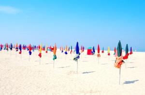 a row of umbrellas in the sand on a beach at Appartement Marina magnifique vue in Deauville