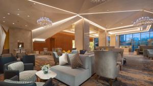 a lobby of a hotel with chairs and tables at Holiday Inn Beijing Focus Square by IHG in Beijing