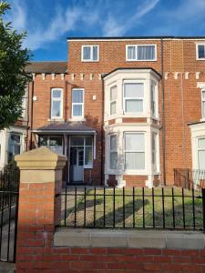 a brick house with a fence in front of it at 70 Southfield in Middlesbrough
