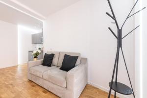 Sala de estar blanca con sofá y lámpara en A e C Homedesign Stampace en Cagliari