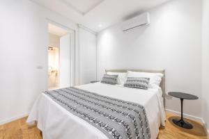 Dormitorio blanco con cama y mesa en A e C Homedesign Stampace, en Cagliari