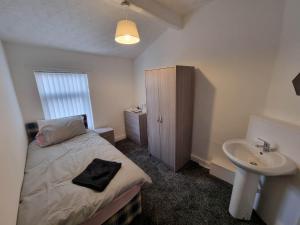 a small bedroom with a bed and a sink at 70 Southfield in Middlesbrough