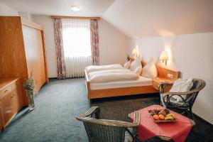 ein Hotelzimmer mit einem Bett und einem Tisch mit Obst in der Unterkunft Appartementhaus Achmannhof in Bad Füssing