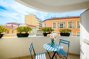 balkon z 2 krzesłami i wazą kwiatów w obiekcie Studio a Nice w Nicei