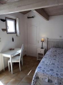 1 dormitorio con cama, mesa y ventana en Les Bois Flottés en Ré en Sainte-Marie-de-Ré