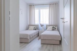 a bedroom with two beds and a window at Apartament Green Lake - Mrągowo in Mrągowo