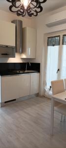 a kitchen with white cabinets and a chandelier at La casina di Ale in Marina di Carrara