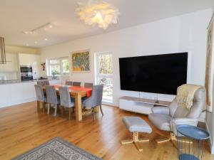 a living room with a dining room table and a flat screen tv at Woodhall in Bodmin