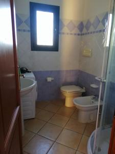 a bathroom with a sink and a toilet and a window at Residence Edilmare San Teodoro in San Teodoro