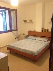 ラ・マッダレーナにあるLa casa Al Portoのベッドルーム(ベッド1台、窓付)