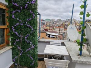 a balcony with a green wall with purple flowers at Peramira in Istanbul