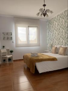 ein Schlafzimmer mit einem großen Bett und einem Fenster in der Unterkunft Falda do Pedroso in Santiago de Compostela