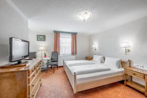A bed or beds in a room at Gasthof Schroll