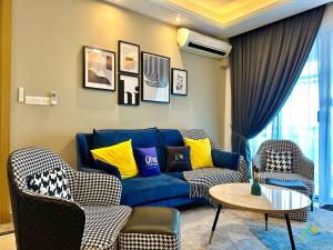a living room with a blue couch and chairs at R&F Princess Cove @ UHA in Johor Bahru