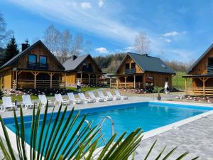 a resort with a swimming pool and some buildings at Na Jasieniu in Ustrzyki Dolne