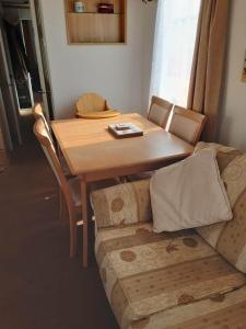 a wooden table and a couch in a living room at 6 BERTH DELUXE CARAVAN PG73 GOLDEN PALM in Chapel Saint Leonards
