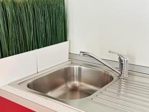 Un fregadero de acero inoxidable en una cocina con una planta verde. en Cozy Apartment Center, en Bérgamo 23 fotos más