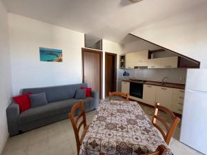 a kitchen and a living room with a table and a couch at Appartamenti Bella Vista in Lampedusa