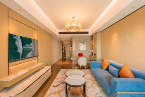 Una sala de estar con un sofá azul y una mesa. en Howard Johnson Plaza by Wyndham Blue Bay Sihanoukville, en Sihanoukville