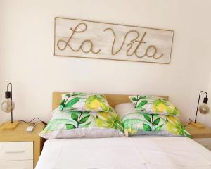 1 dormitorio con 1 cama con un cartel en la pared en LA VITA APARTMAN, en Balatonfüred
