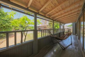 a porch with two rocking chairs on it at guesthouse minkä in Amami