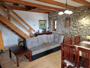 a living room with a couch and a stone wall at Vacation House Donacka Gora in Rogatec