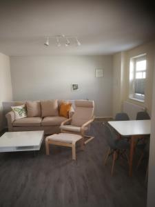 uma sala de estar com um sofá, cadeiras e uma mesa em AppartementHaus Nienburg em Nienburg