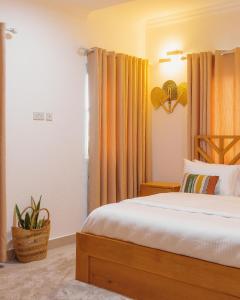 a bedroom with a bed with orange curtains at The Avery Apartments, Dzorwulu in Accra