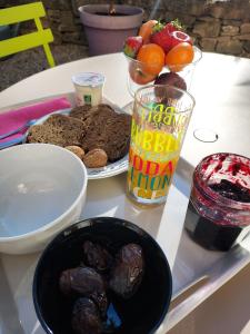 un tavolo con un piatto di cibo e un cesto di frutta di Chambre d'hôte chez Florence a Vourles