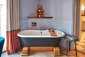 a bath tub in a bathroom with a bottle of beer at Hotel Du Vin Poole in Poole