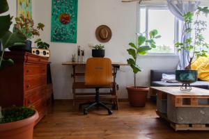 a room with a desk with a chair and potted plants at The Magic Truck in ‘Amqa