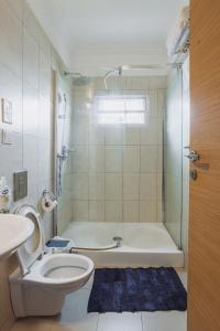 a bathroom with a toilet and a bath tub at The Avery Apartments, Dzorwulu in Accra