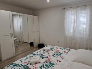 um quarto com uma cama com colcha floral em Apartmani Pina 2 em Kaštela