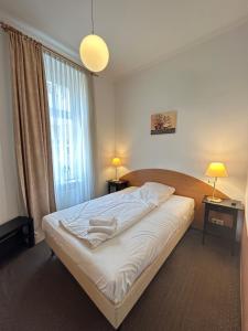 a bedroom with a bed and a large window at Hotel Adam in Berlin