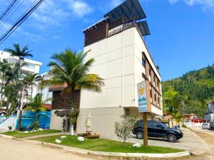 a building with a car parked in front of it at Pousada Ubuntu in Ubatuba