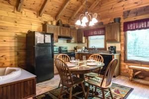 a kitchen with a table and chairs and a black refrigerator at Fawn Cabin, 1 Bedroom, Sleeps 4, Hot Tub, Private, Pets, Gas Fireplace in Gatlinburg