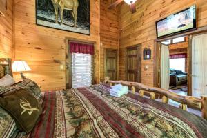 a bedroom with a bed in a log cabin at Fawn Cabin, 1 Bedroom, Sleeps 4, Hot Tub, Private, Pets, Gas Fireplace in Gatlinburg