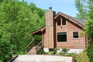 a wooden house with a staircase in front of it at Fawn Cabin, 1 Bedroom, Sleeps 4, Hot Tub, Private, Pets, Gas Fireplace in Gatlinburg