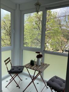a table and two chairs in a room with windows at Falda do Pedroso in Santiago de Compostela