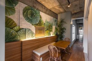 a dining room with a table and plants on the wall at Birupaku in Shizuoka
