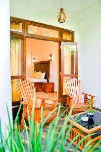 a bedroom with a bed and two chairs and a table at Villa Paradise Ocean in Bentota