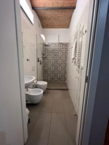a bathroom with two toilets and a sink and a shower at Locanda dei Sette Limoni in Vada