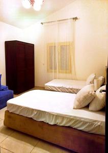 - une chambre avec 2 lits et une fenêtre dans l'établissement Villa amoun, à Sidi Krir