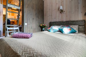 een slaapkamer met een groot bed met kussens erop bij Jūras dzintars in Ainaži