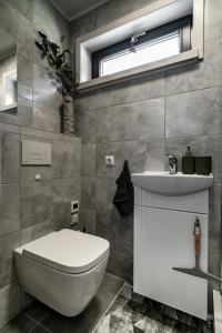 een badkamer met een wit toilet en een wastafel bij Jūras dzintars in Ainaži
