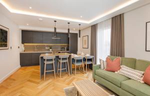 Apartment 21 Hudson Quarter Luxury Apartments في يورك: غرفة معيشة مع أريكة ومطبخ