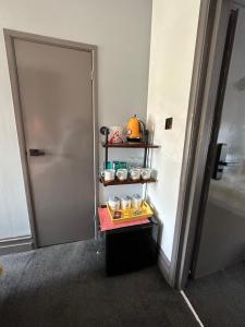 a room with a door and a shelf with food at Green Corner Villa - Cosy Luxury in Central Torquay with Free Parking & EV in Torquay