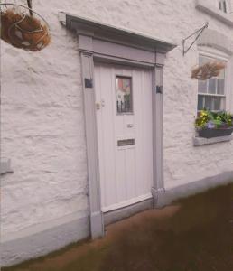 a white door on a white building with a window at The kings in Denbigh