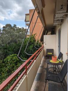 - Balcón con mesa y sillas en un edificio en Cozy apartm.near Metro Ag.Marina, en Atenas