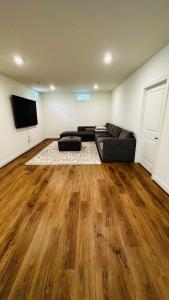 uma sala de estar com um sofá e uma televisão de ecrã plano em Brand New Spacious 2br - 2bth Basement em Woodbridge
